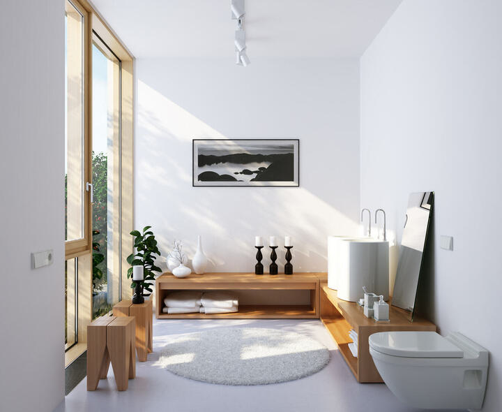 Minimalistisches Badezimmer in Weiß mit viel Tageslicht, Holzmöbeln und rundem Teppich als Kontrast